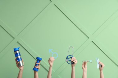 Spor ekipmanlı kadın eller, erkek işareti ve yeşil arka planda açık mavi kurdele. Prostat kanseri kavramı