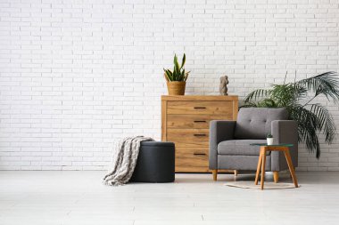 Koltuk, çekmeceler ve salonda ekoseli puf.