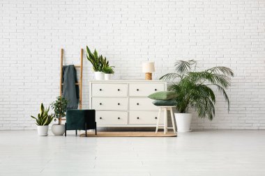 Pouf, çekmece sandığı ve oturma odasının içinde ekoseli merdiven.