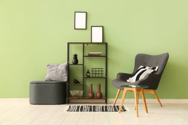 Koltuk, raf ünitesi ve oturma odasında yastıklı puf.