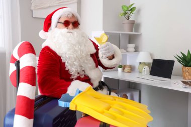 Evde kokteyl ve bavullarla Noel Baba. Temmuz 'da Noel