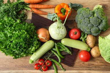 Ahşap mutfak tezgahında farklı taze sebzeler.