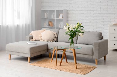 Gri kanepe ve sehpanın üzerinde nilüfer çiçekleri olan şık bir oturma odası.