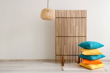 Renkli yastıklar, odada ışık duvarının yanında katlanmış perdeler.