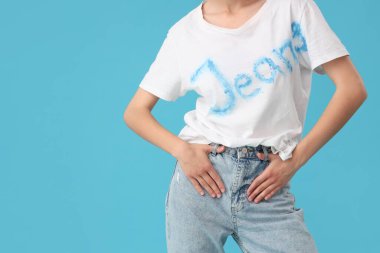 Mavi arka planda şık kotlu güzel genç bayan, yakın plan.