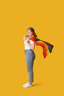 Beautiful young woman with LGBT flag on yellow background clipart
