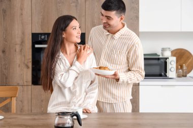 Mutfakta kahvaltı yapan mutlu genç çift.