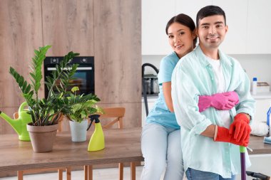 Mutfağı temizlerken kucaklaşan mutlu genç çift