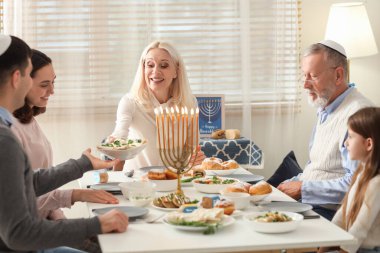 Olgun bir kadın Hanuka 'da aile yemeği yiyor.
