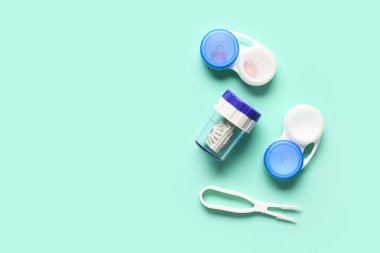 Kontak lensler ve turkuaz arka planda cımbız için konteynırlı gözlük