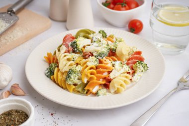 Brokoli ve peynirli nefis fusilli makarna, arka planda açık tabakta, yakın plan.