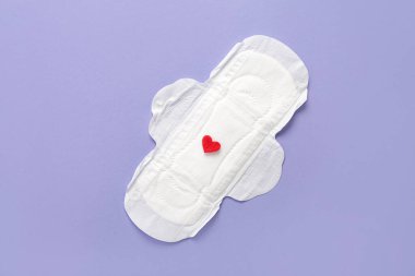 Mor zemin üzerinde kırmızı kalp olan adet yastığı