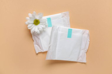 Bej arka planda kasımpatı çiçekli adet pedleri