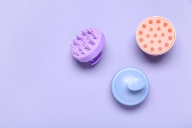 Mor arka planda saç derisi masaj aletleri.