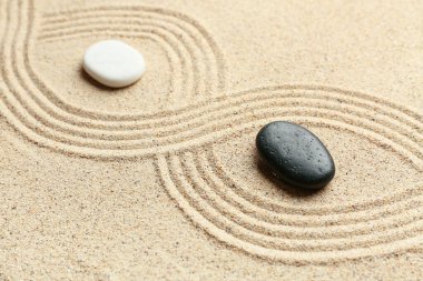 Black and white stones on sand with lines. Zen concept clipart