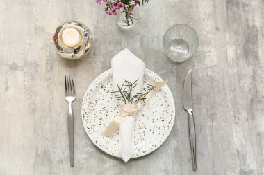Gri arkaplanda yanan mum ve biberiyeli güzel masa ayarları