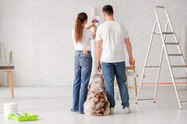 Şirin köpekleri ve palet örnekleriyle genç bir çift yeni evlerinin tasarımını planlıyorlar.