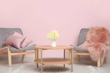 Oturma odasının içinde güzel bir narsisli vazo.