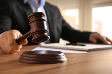 Tokmaklı erkek yargıç ve masadaki belgeler.