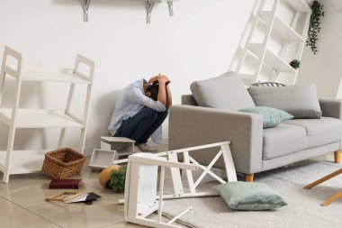 Deprem sırasında evdeki ışık duvarının yanında oturan genç kadın.