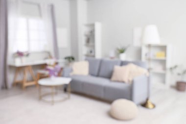 Kanepe, masa ve vazolarda leylak çiçekleri olan bulanık oturma odası manzarası