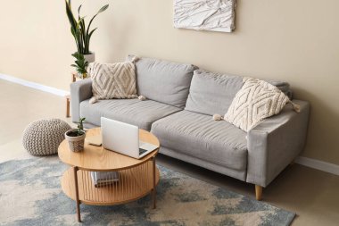 Rahat kanepesi, sehpası ve dizüstü bilgisayarı olan bir oturma odası.