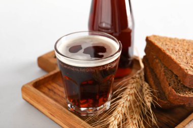 Gri arka planda bir bardak lezzetli kvass ve ekmek