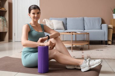 Evdeki paspasın üzerinde köpüklü tekerlekli sandalyesi olan genç bir kadın.