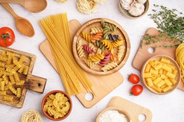 Farklı türde pişirilmemiş makarna, domates ve kekik içeren kompozisyon