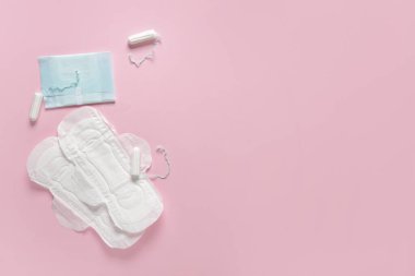 Pembe arka planda tamponları olan adet pedleri.