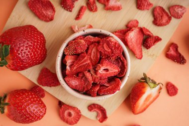 Turuncu arka planda lezzetli dondurulmuş çilekli kase.