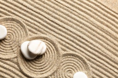 Kumun üzerinde desenli beyaz taşlar. Zen kavramı