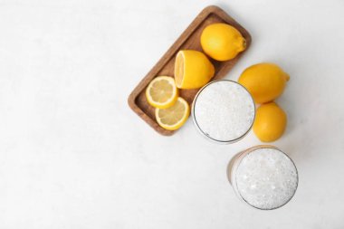 Taze bira bardakları ve beyaz arka planda limonlu ahşap tahta.