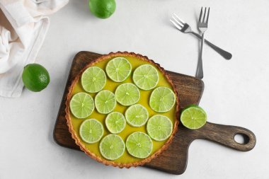 Beyaz arka planda lezzetli kireç tartı olan ahşap tahta.