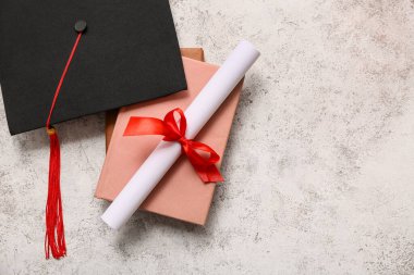 Diploması ve gri zemin üzerinde harç tahtasıyla