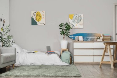 Yatak ve çekmeceleri olan bir öğrenci odası.