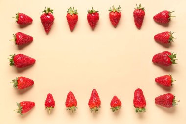 Sarı zemin üzerinde taze çileklerden yapılmış bir çerçeve.