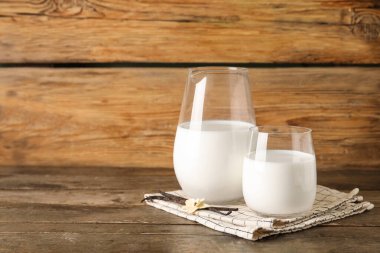 Bir bardak taze vanilyalı süt, sopalar ve çiçek.