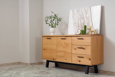 Dekor, bambu saplı ahşap dolap ve gri duvarın yanındaki resim.