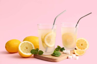 Pembe arka planda naneli ve şekerli taze limonata.
