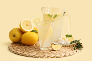 Bir bardak taze limonata ve sarı arka planda nane şekeri.