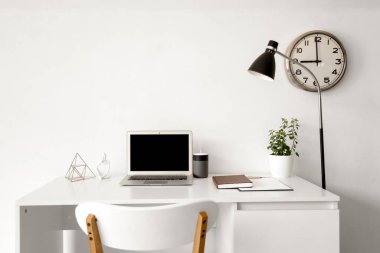 Işık ofisindeki masada dizüstü bilgisayarı olan hava nemlendirici.