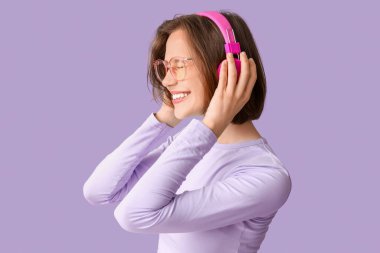 Leylak arka planında modern kulaklıklı mutlu genç kadın.