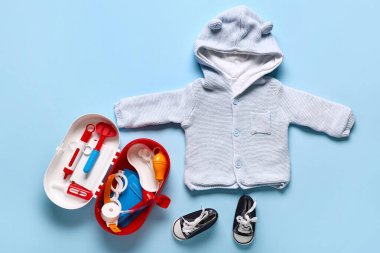 Mavi arka planda çocuk ayakkabısı ve kapüşonlu ilk yardım çantasını aç. Üst görünüm