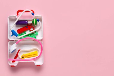 Pembe arka planda ilk yardım çantasını aç. Üst görünüm