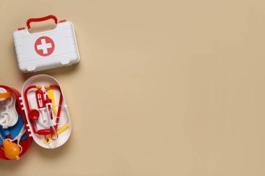 Bej arka planda oyuncak ilk yardım kitleri. Üst görünüm