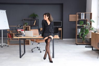 Ofisteki masanın yanında Afro-Amerikan çekici bir sekreter.