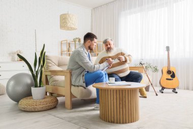 Kıdemli adam evde bakıcıyla konuşuyor.