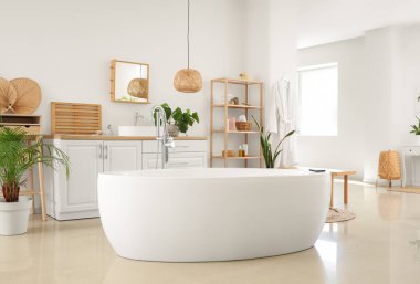 Ev bitkileri ve küveti olan modern bir banyo.