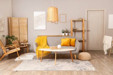 Gri kanepesi, masası ve koltukları olan rahat bir oturma odası.